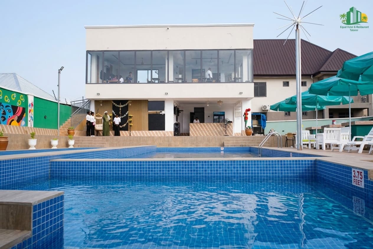 Swimming pool with sun loungers at Equal Hotel Tamale